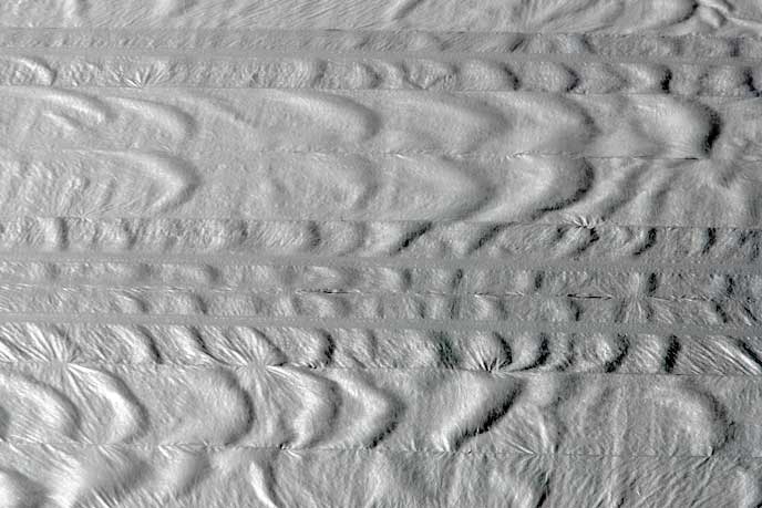 Wind created waves on the protect layer covering the turf at Invesco Field and gave it an unfamiliar look.